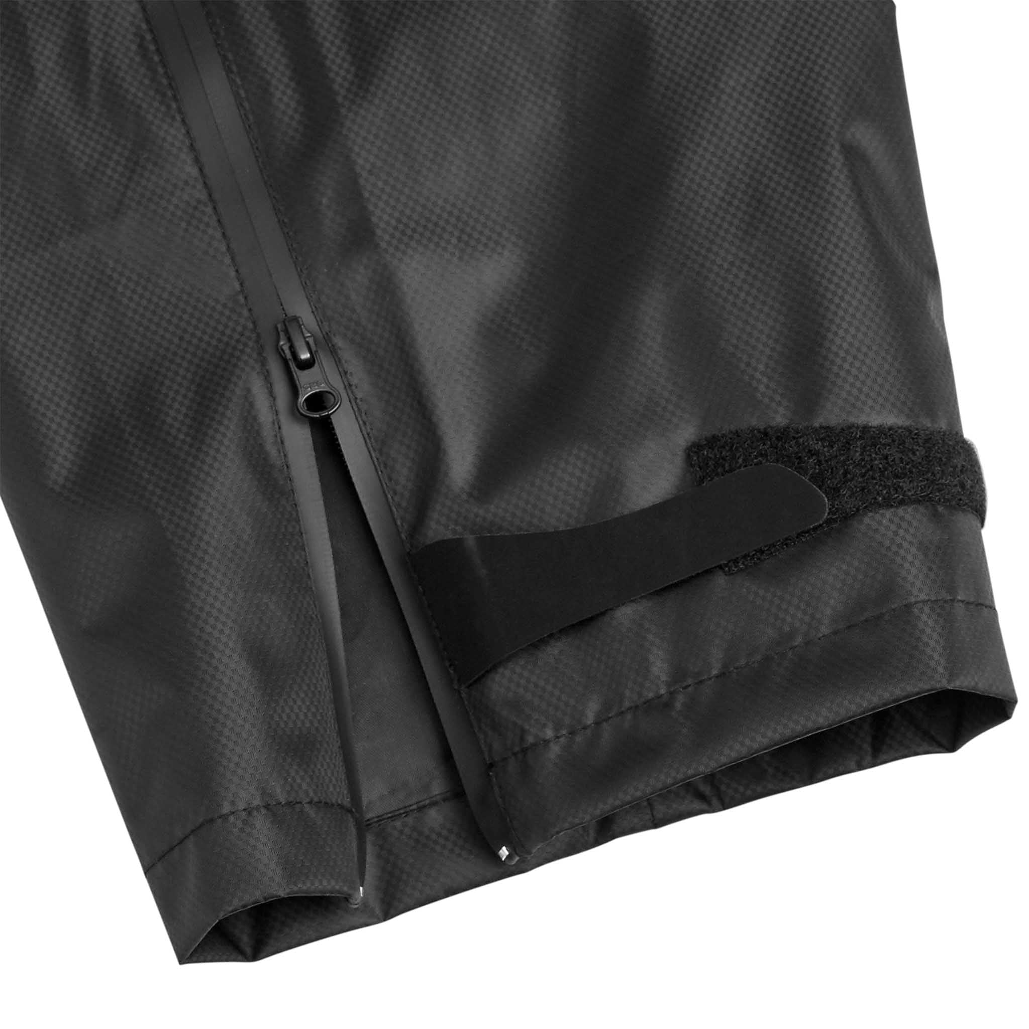 Nærbilde av svarte All-weather pants Monaco v24, Match & Training wear, med glidelås og borrelås ved ankelen.