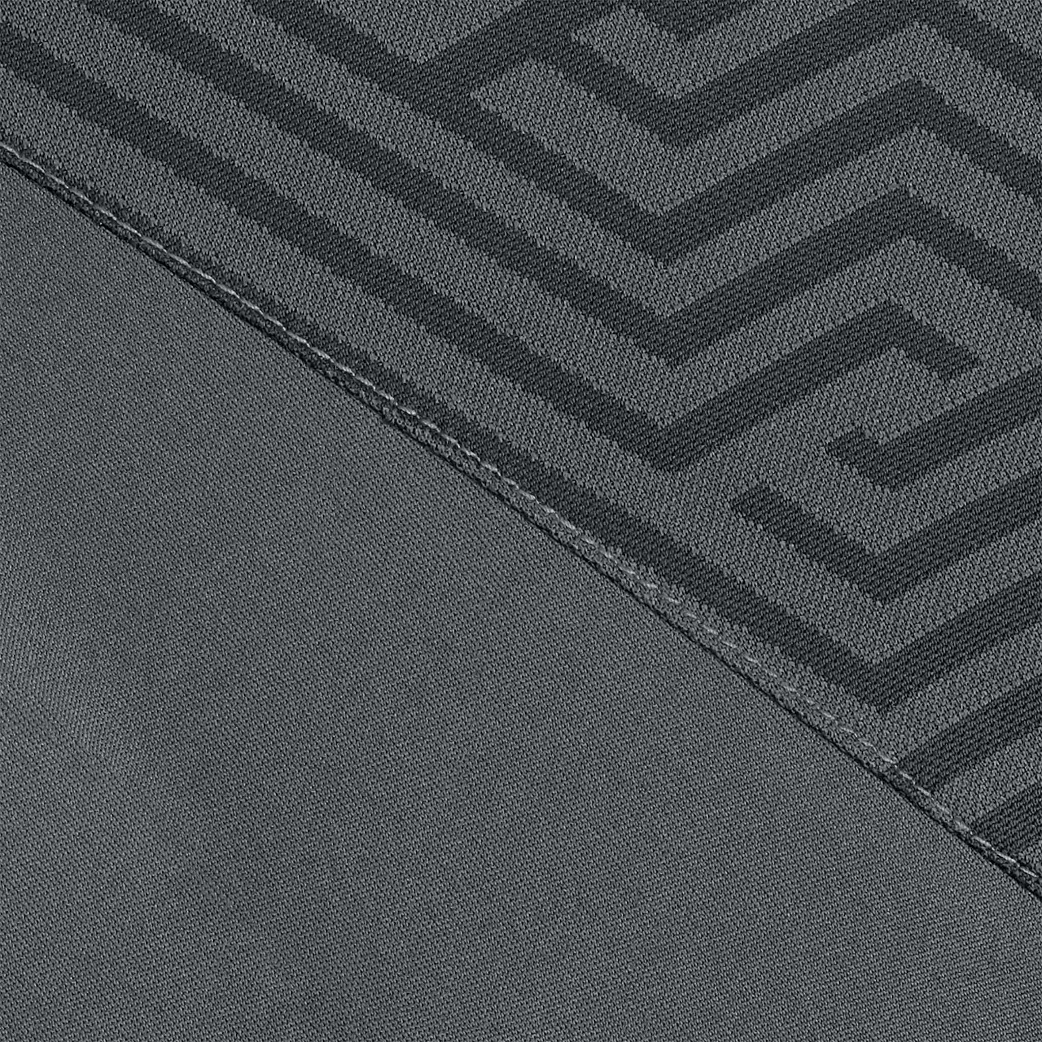 Nærbilde av Technical Polo Monaco v24 fritidsklær, grått stoff med sort geometrisk labyrintmønster