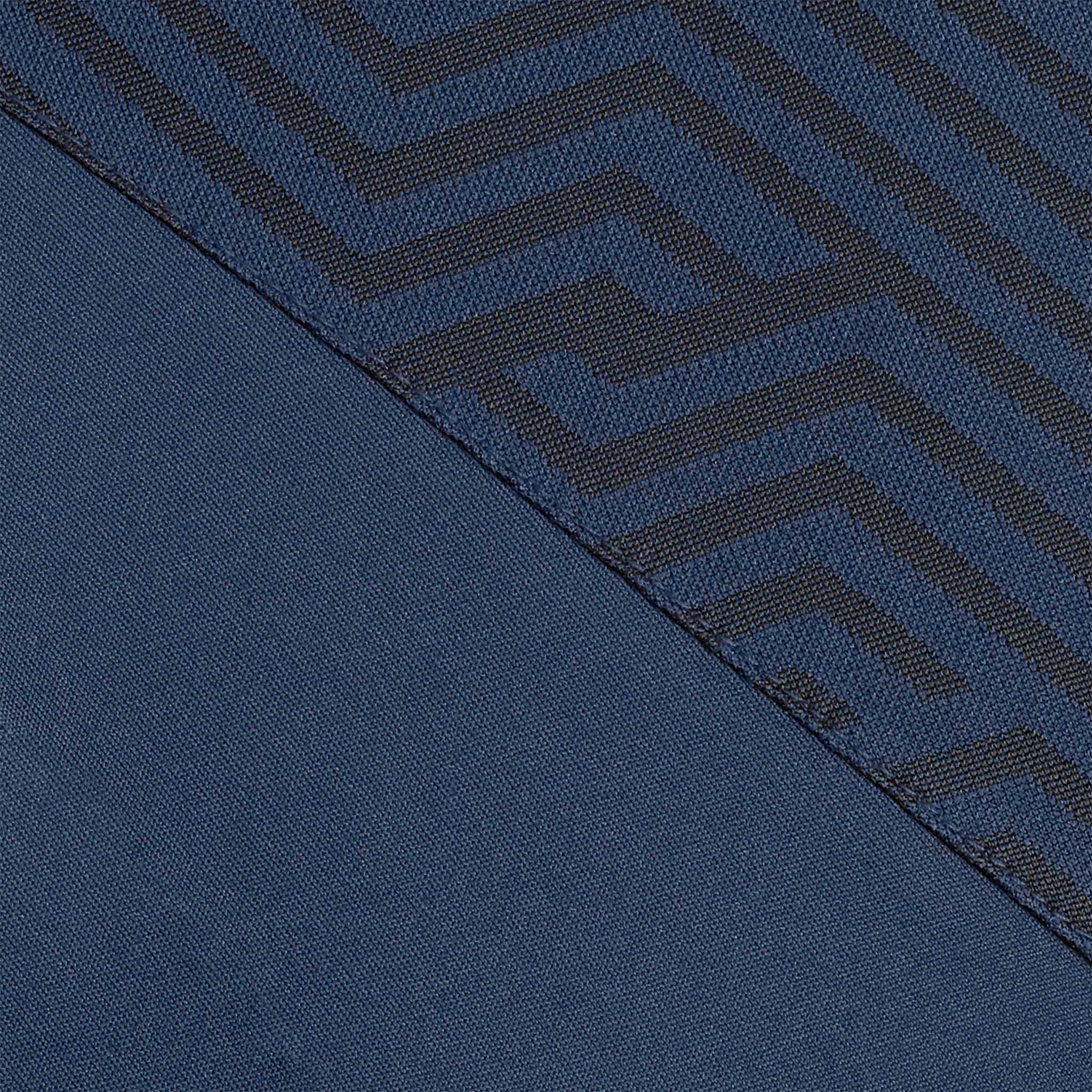 Nærbilde av Technical Polo Monaco v24 fritidsklær, marineblått stoff med geometrisk labyrintmønster i mørkere toner.