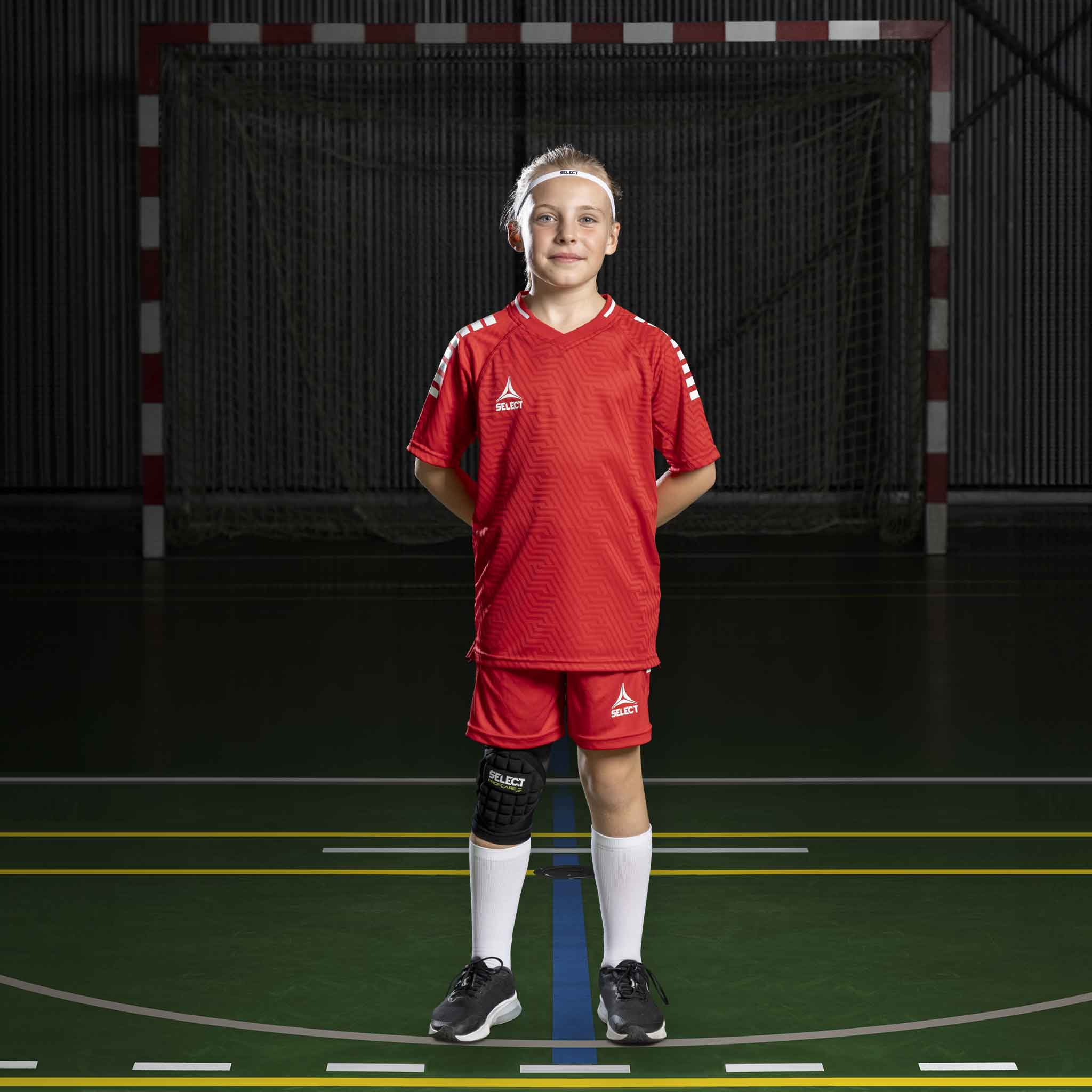Håndballgutt i røde Player shorts Monaco v24, Match & Training-tøy, sett forfra på innendørsbane.