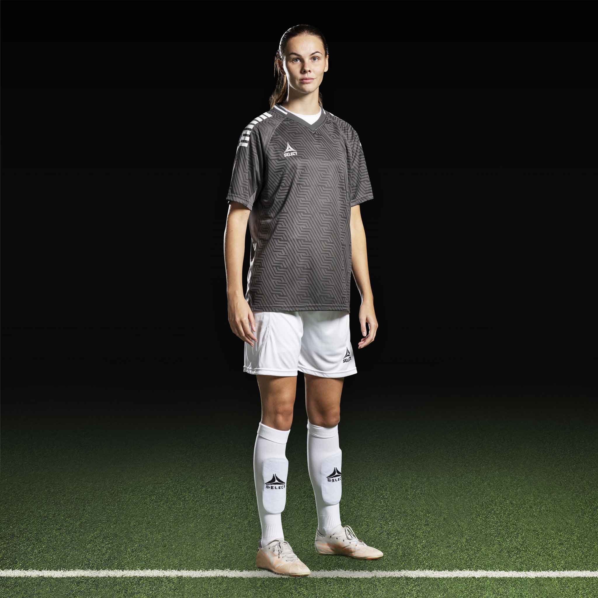 Kvinnelig fotballspiller i grå Player shirt S/S Monaco v24, hvite shorts og strømper. Match & Training wear.