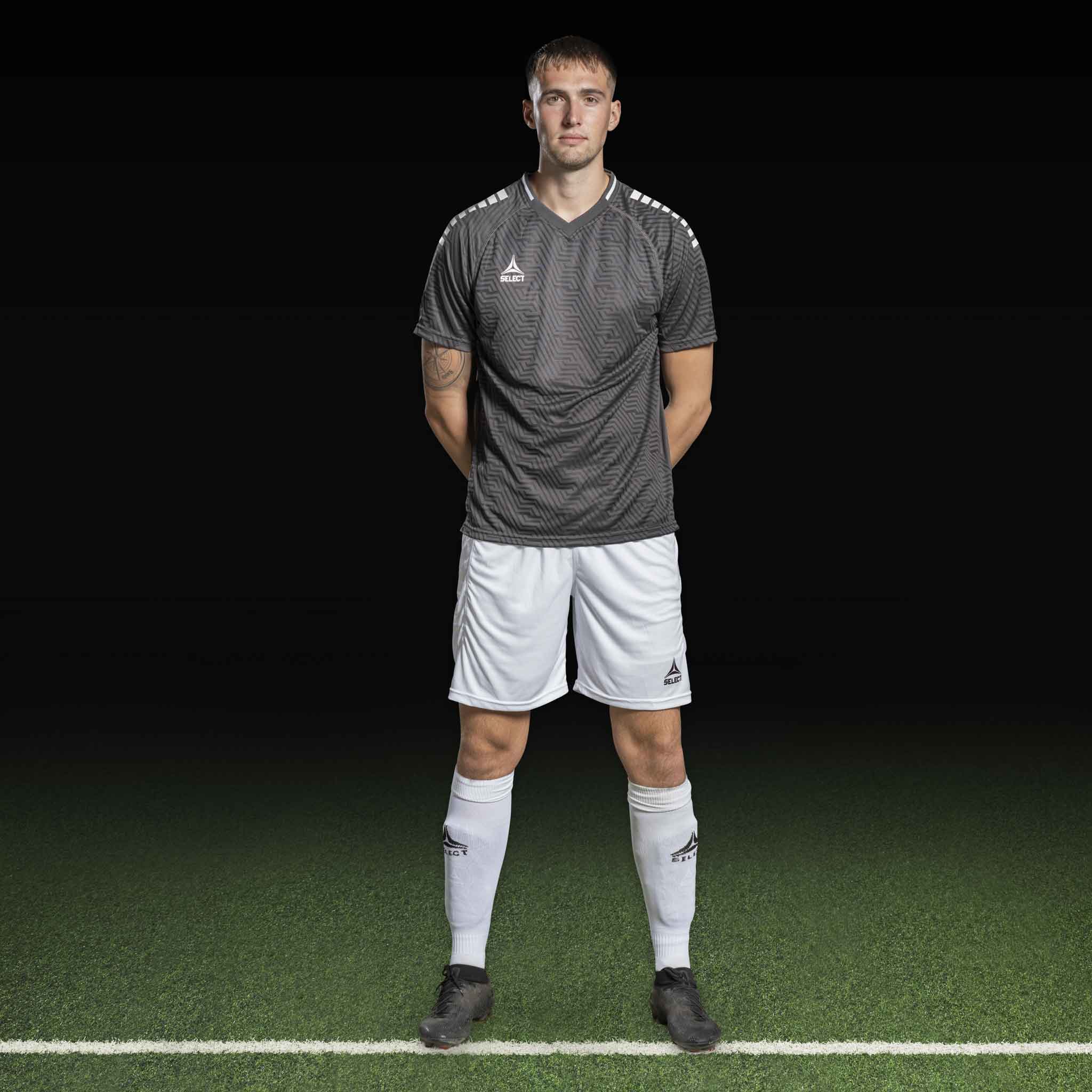Mannlig fotballspiller i grå Player shirt S/S Monaco v24 og hvite shorts, Match & Training wear, forfra.