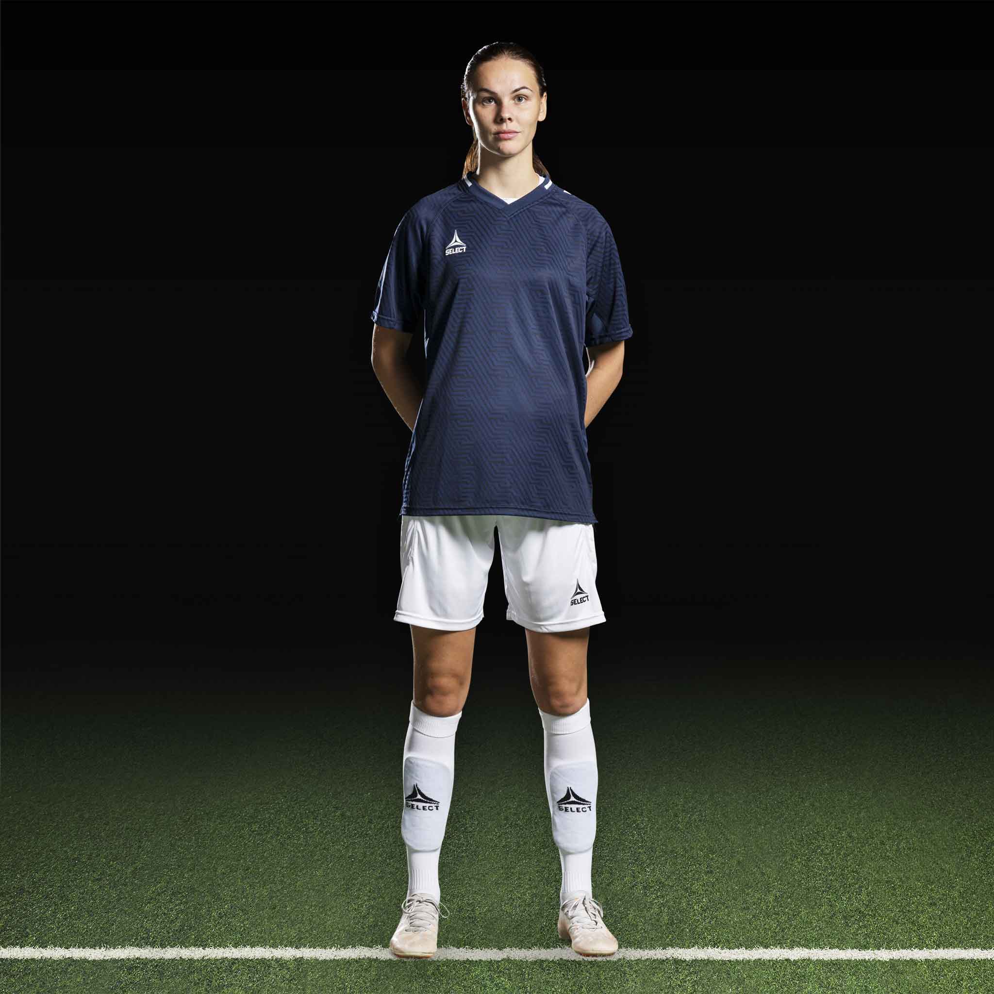 Kvinnelig fotballspiller i marineblå Player shirt S/S Monaco v24 og hvite shorts, Match & Training wear.