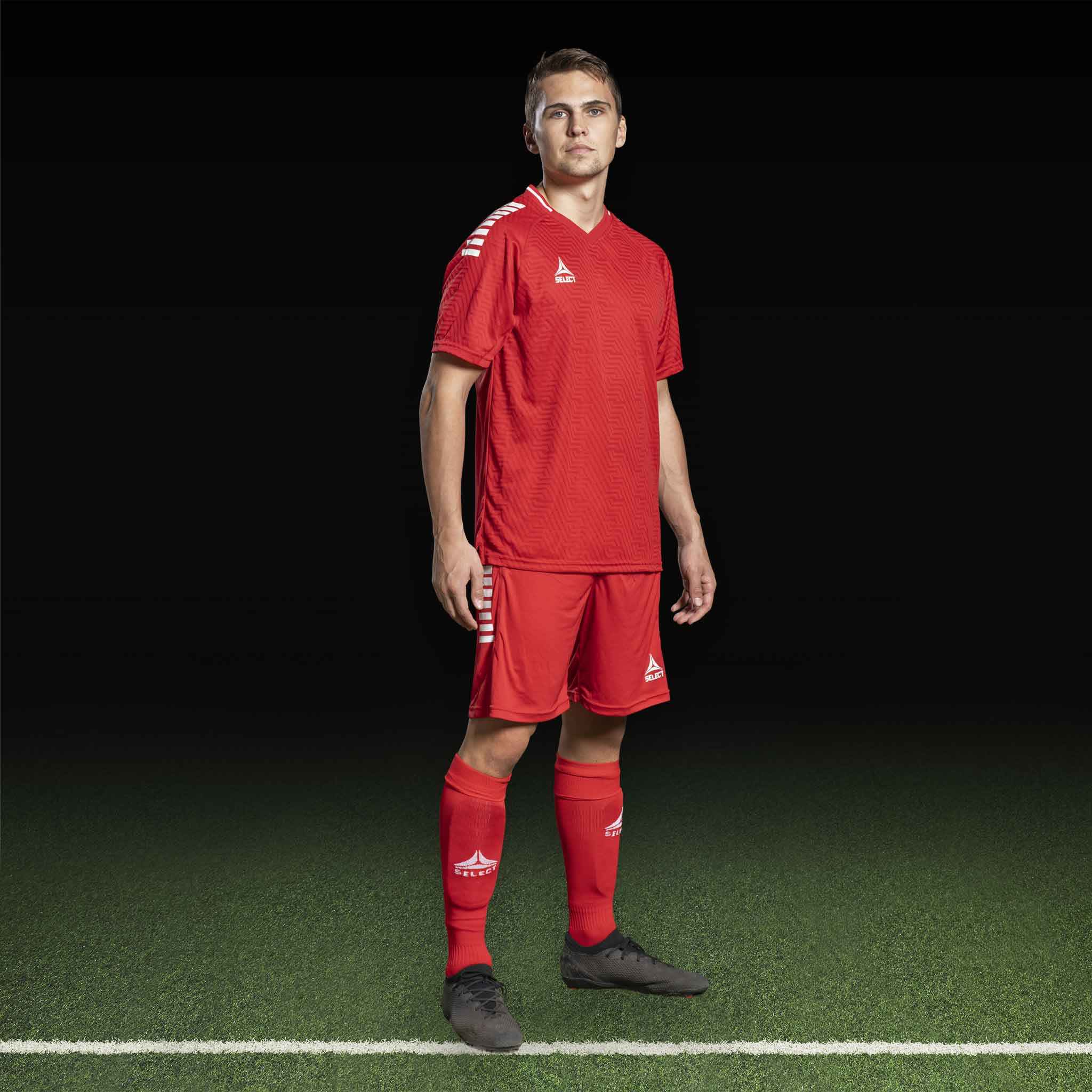 Mannlig fotballspiller i rød Player shirt S/S Monaco v24, Match & Training wear, med hvite striper på skuldrene.