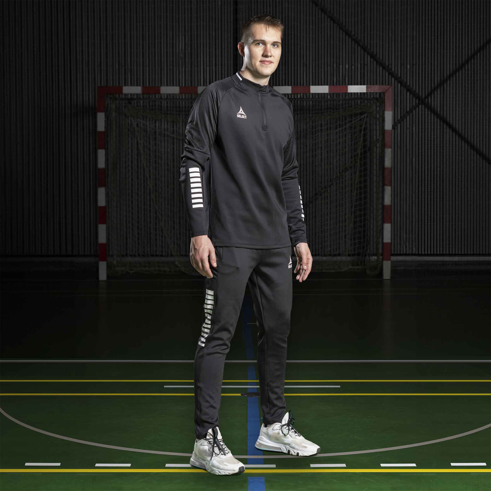 Mannlig håndballspiller i sort Training sweat 1/2 zip Monaco v24, Match & Training wear, på banen.