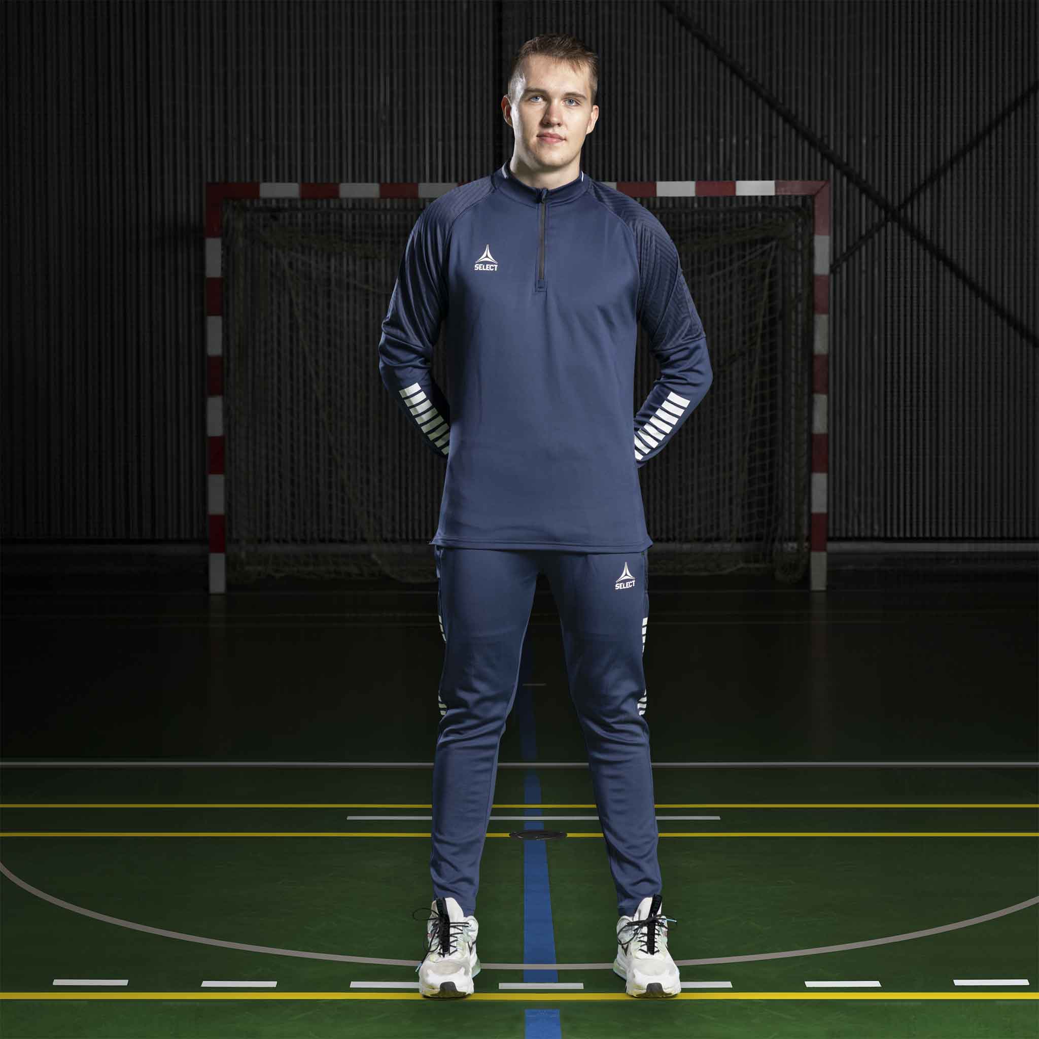 Mannlig håndballspiller i marineblå Training sweat 1/2 zip Monaco v24, Match & Training wear, forfra på banen.