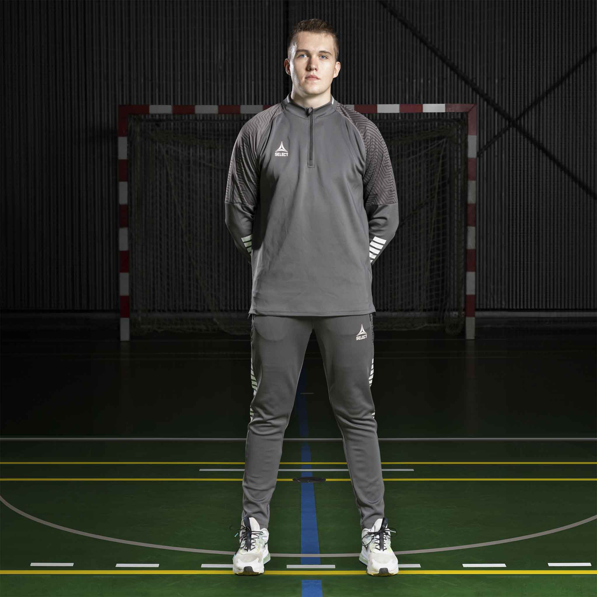 Mannlig fotballspiller i grå Zip jacket Monaco v24 og matchende bukse, Match & Training-tøy, forfra på innendørsbane.