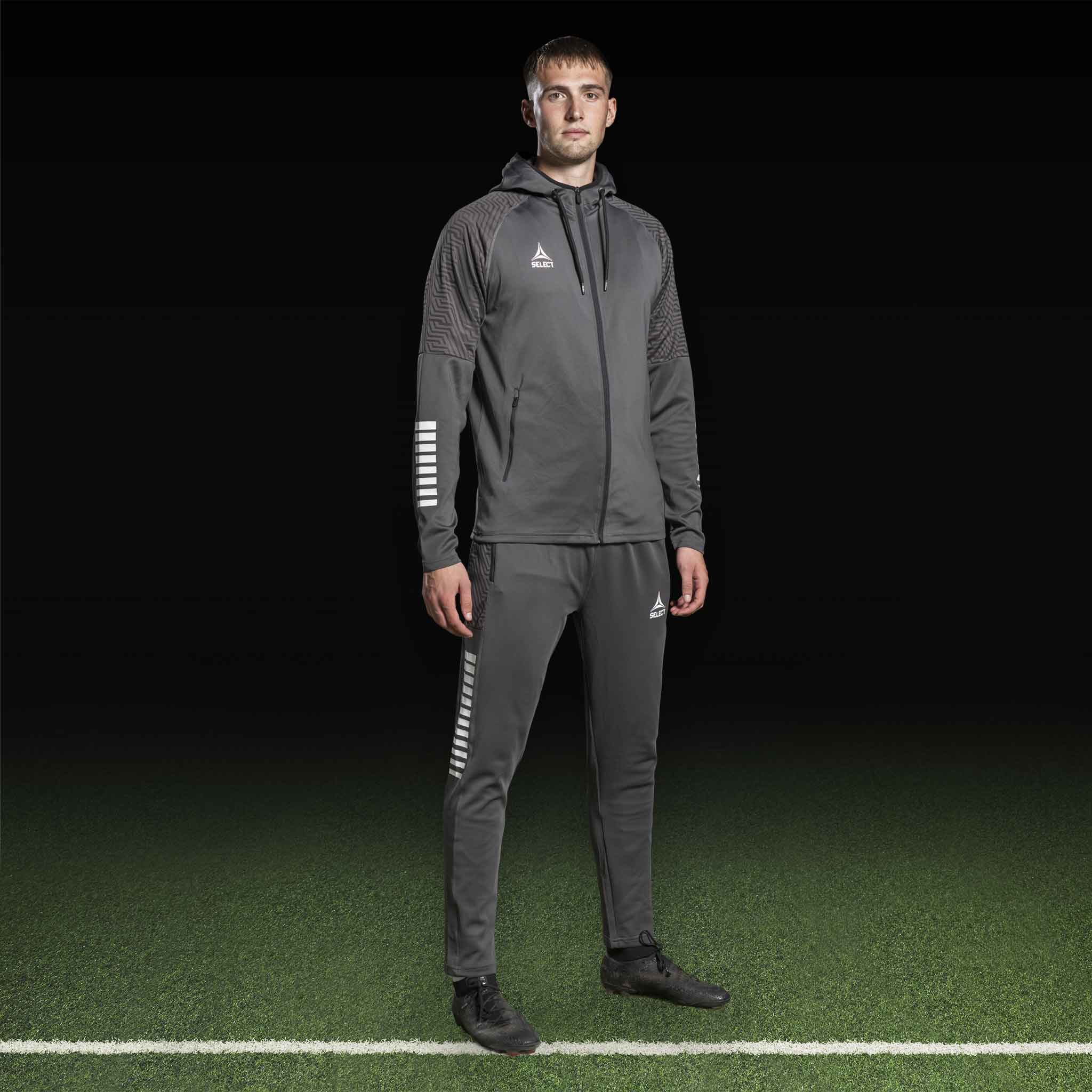 Mannlig fotballspiller i grå og hvit Zip hoodie Monaco v24, Match & Training wear, sett forfra.