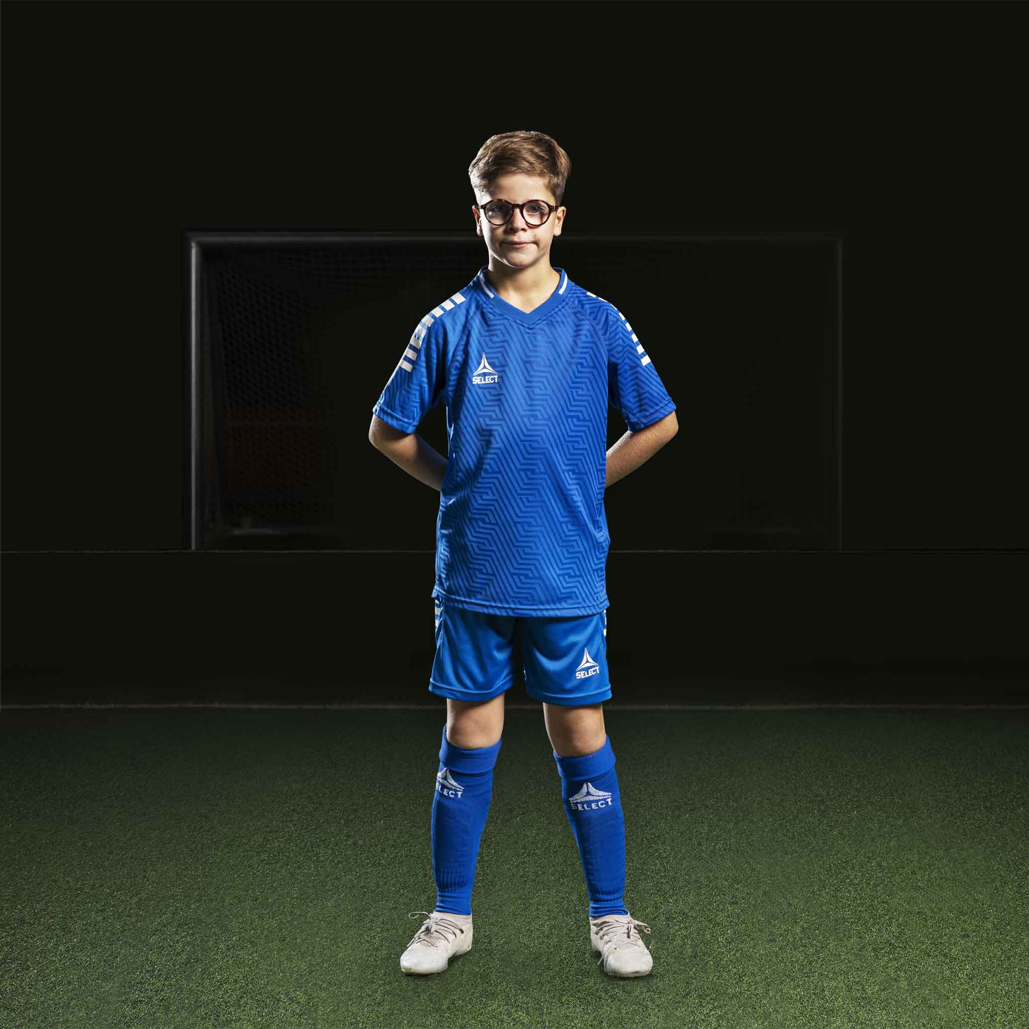 Gutt fotballspiller i blå Player shorts Monaco v24 og matchende trøye, Match & Training wear, sett forfra.