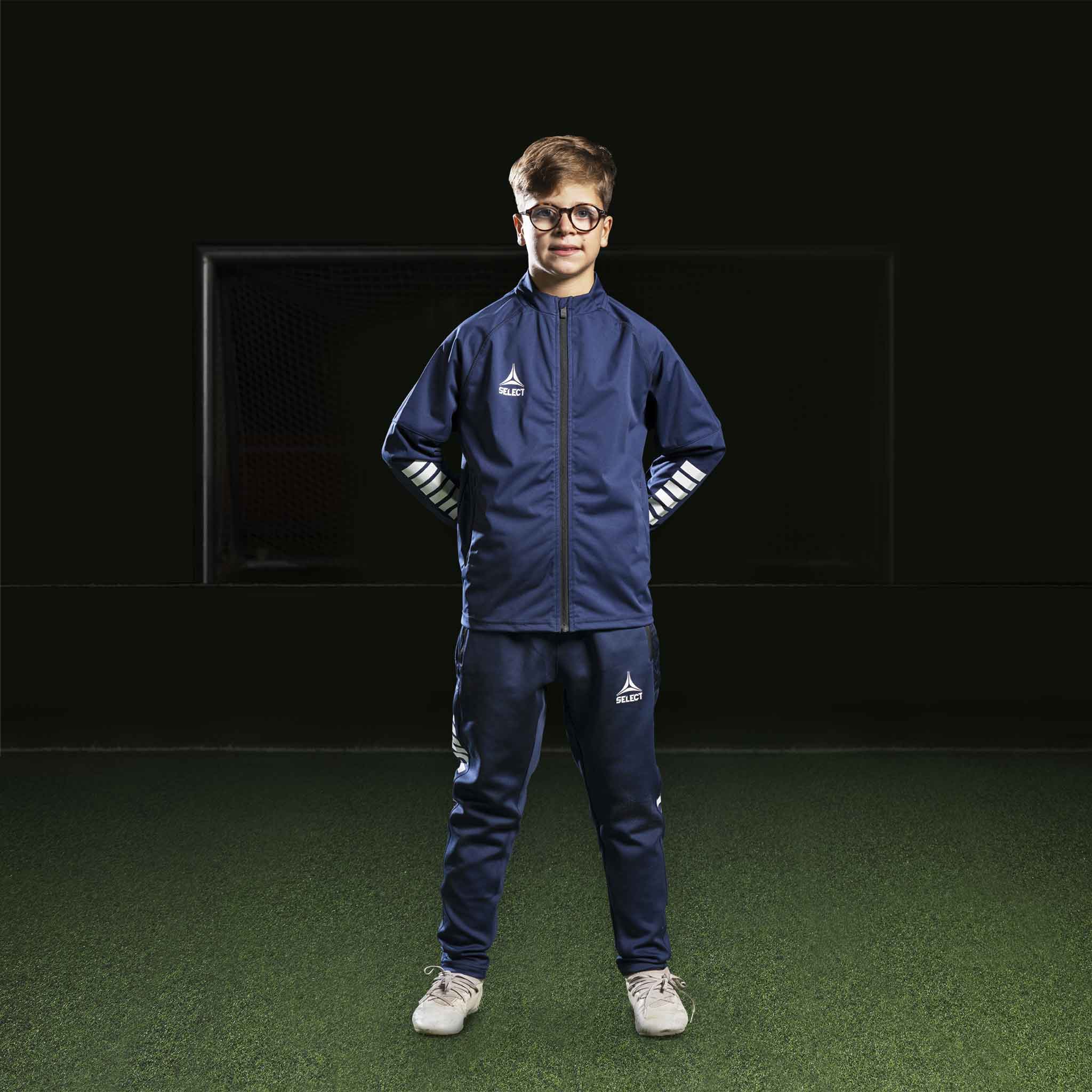 Gutt fotballspiller i marineblå/hvit Zip jacket Monaco v24, Match & Training wear, forfra.