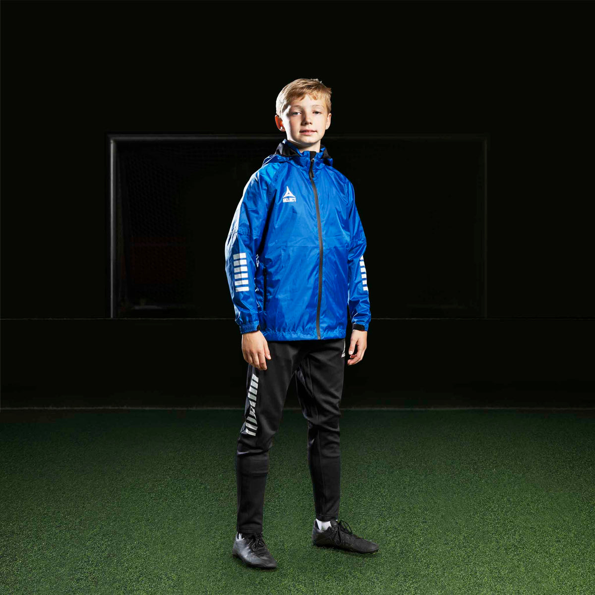 Fotballspillende gutt i blå jakke og svarte Training pants Regular Fit Monaco v24, Match & Training wear.