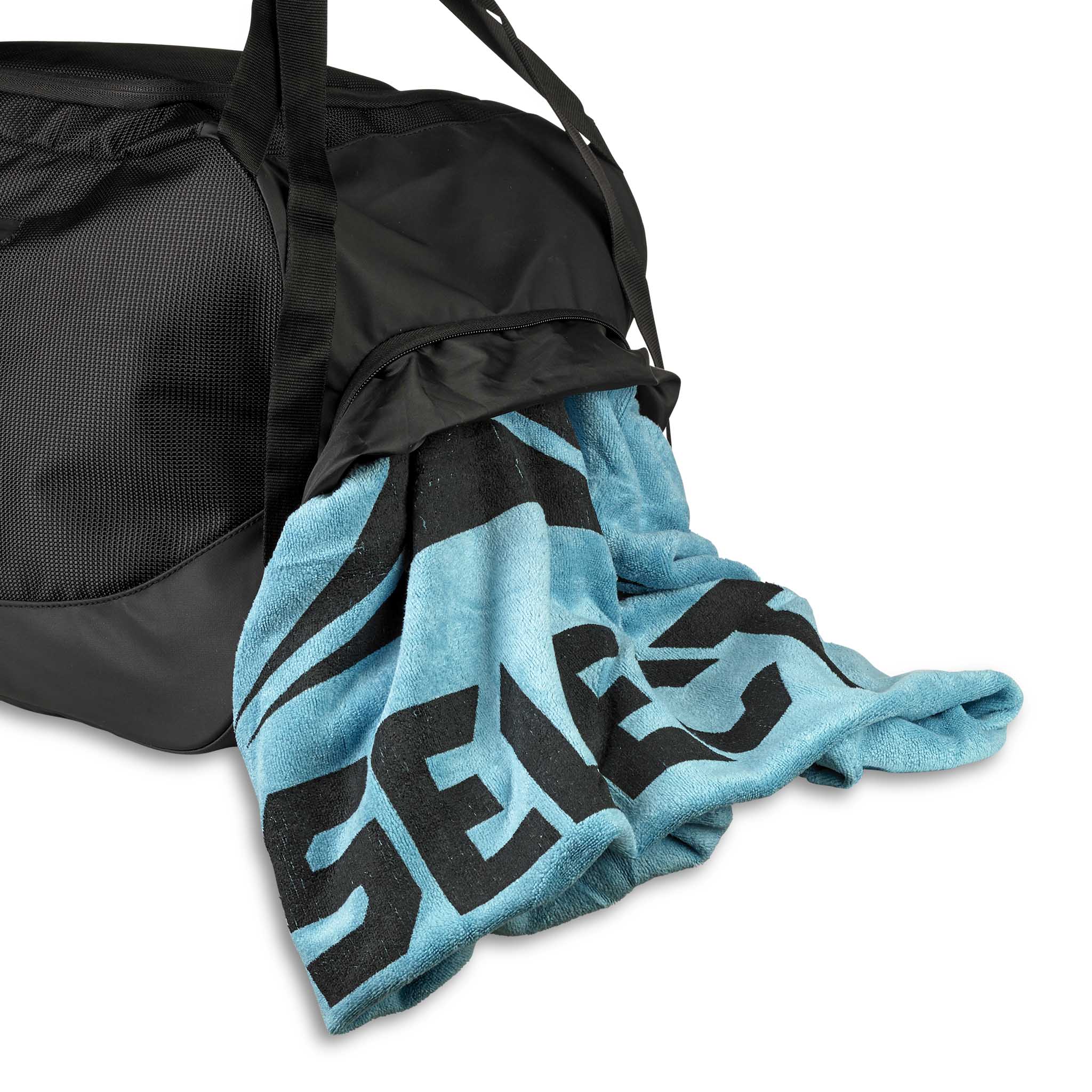 Nærbilde av svart Sportsbag v25 sportsbag med et blått og svart logohåndkle lagt over.