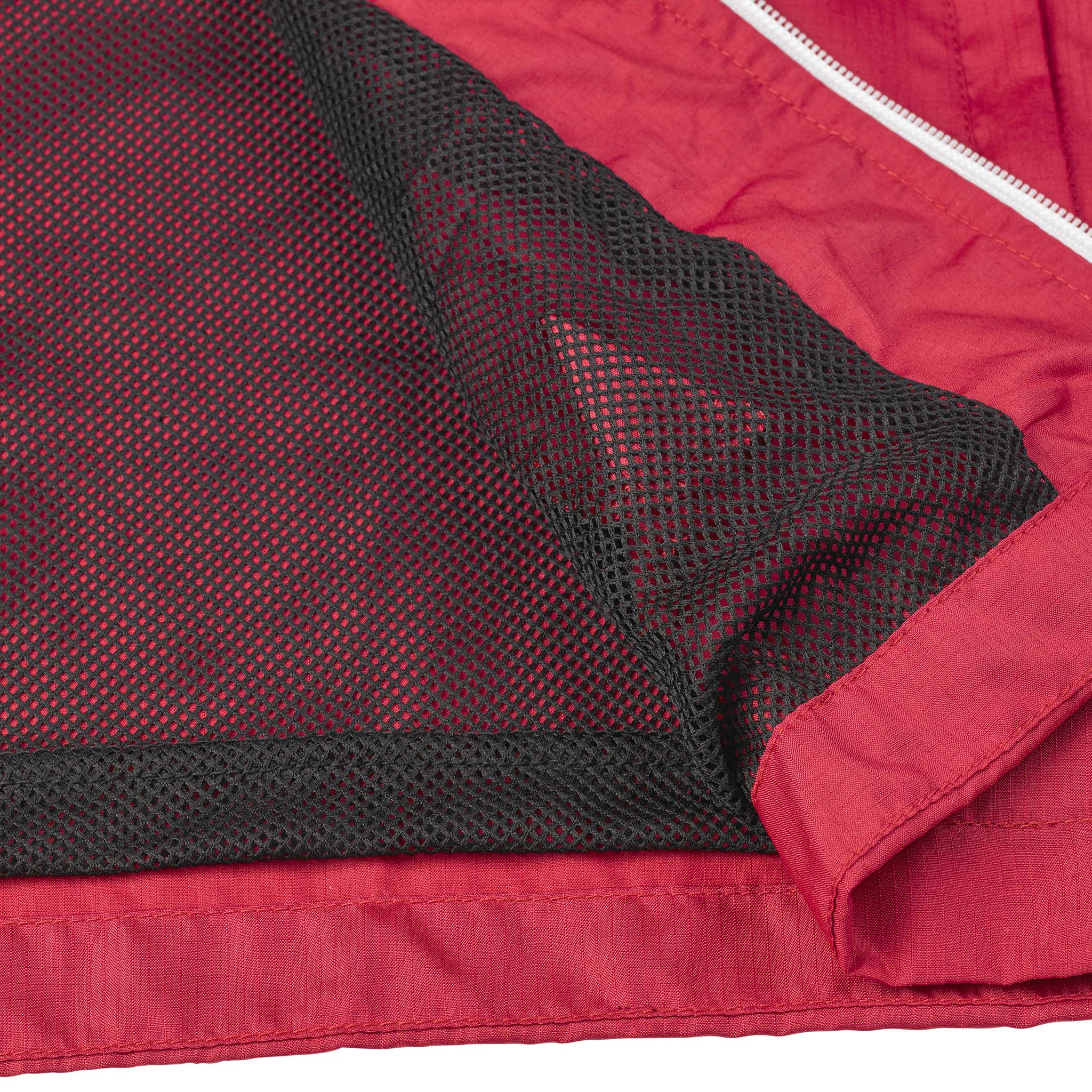 Nærbilde av rød Training jacket Spain v25, svart meshfôr, hvit glidelås. Match & Training wear.