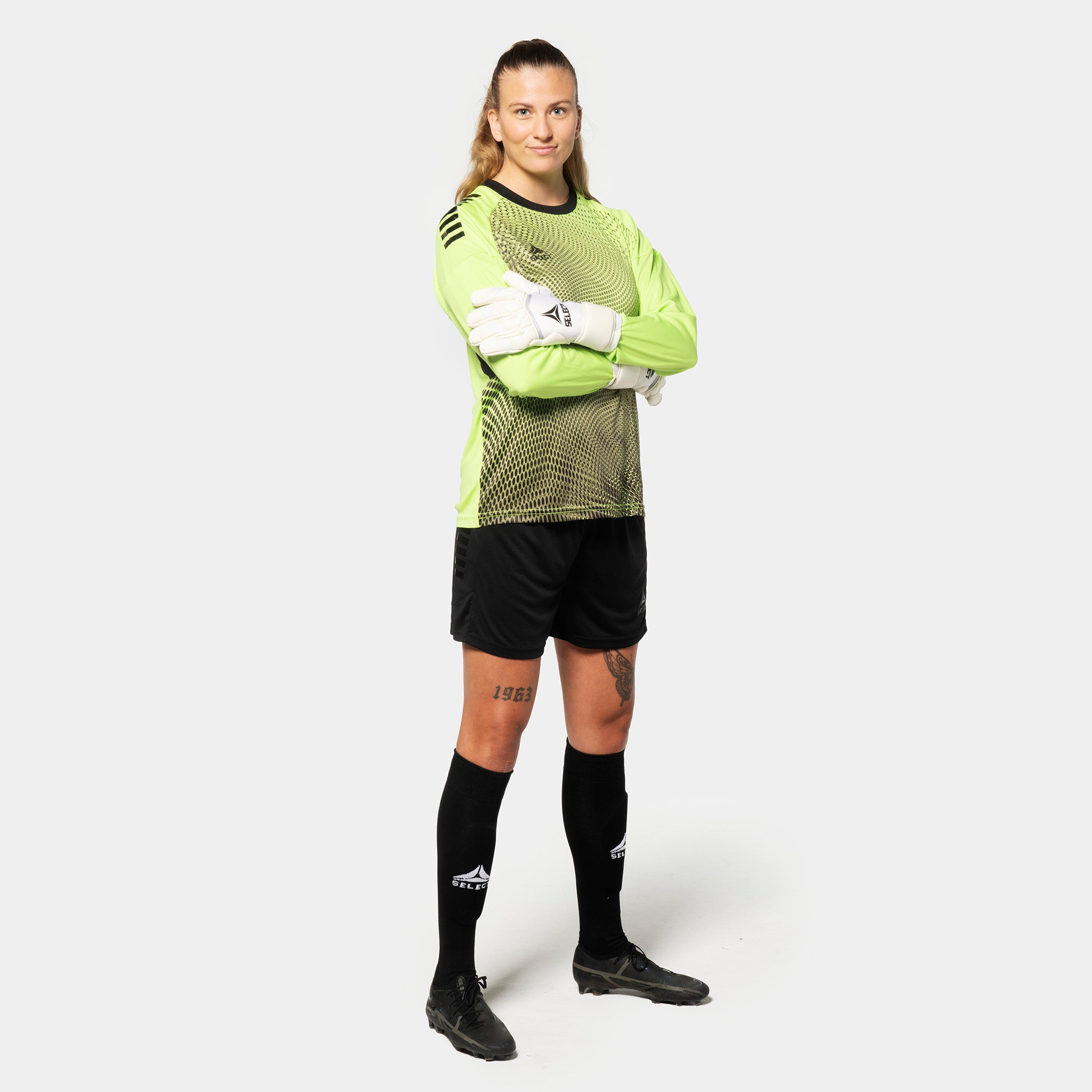 Kvinnelig fotballspiller i limegrønn og sort Goalkeeper shirt Spain v25, keeperklær med sorte shorts og strømper.