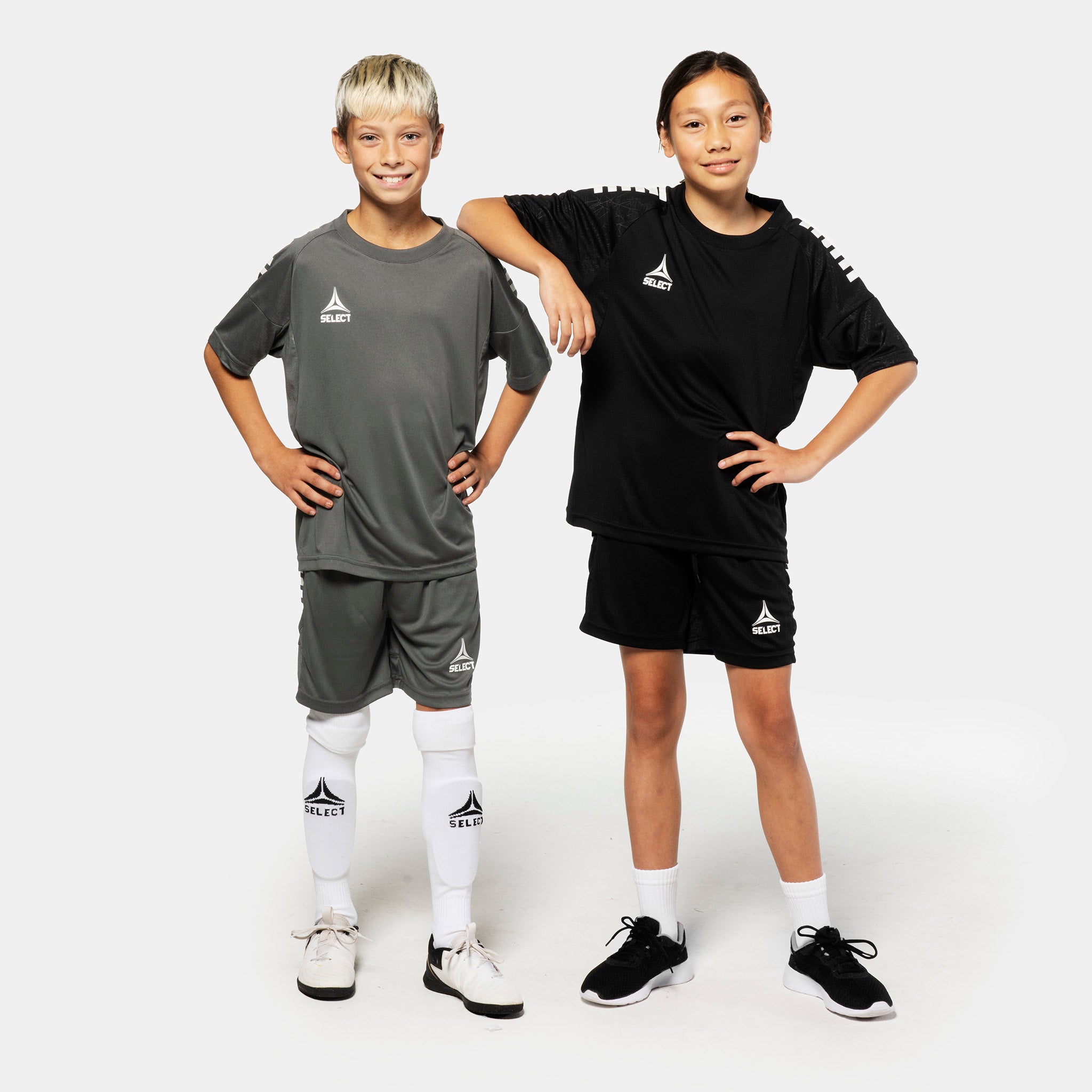 Gutt og jente fotballspillere i grå og sorte Player shorts Spain v25, Match & Training-tøy, sett forfra.