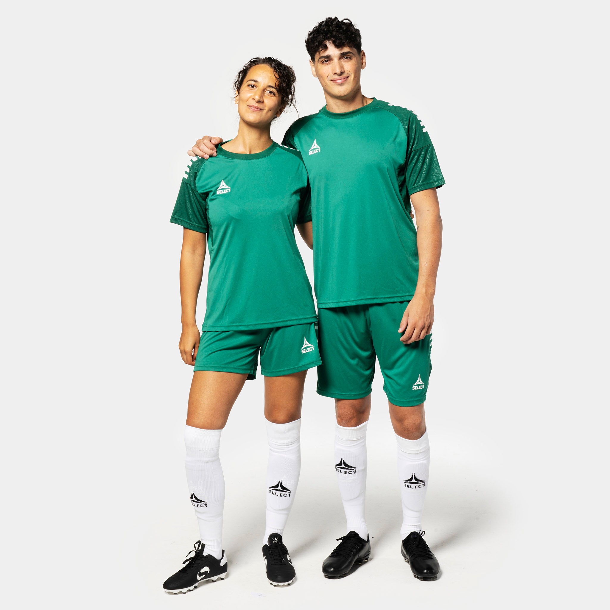 Kvinnelig og mannlig fotballspiller i grønne Player shorts Spain v25, Match & Training wear, med matchende trøyer og hvite strømper.