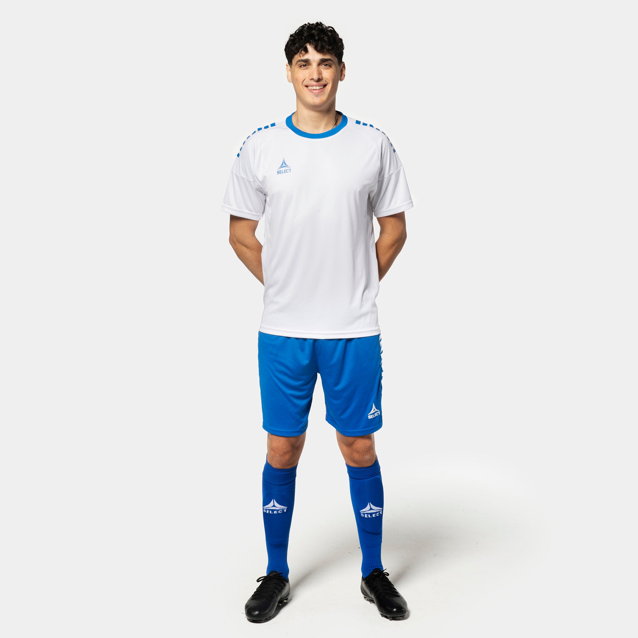 Mannlig fotballspiller i hvit trøye og blå Player shorts Spain v25, Match & Training wear, sett forfra.