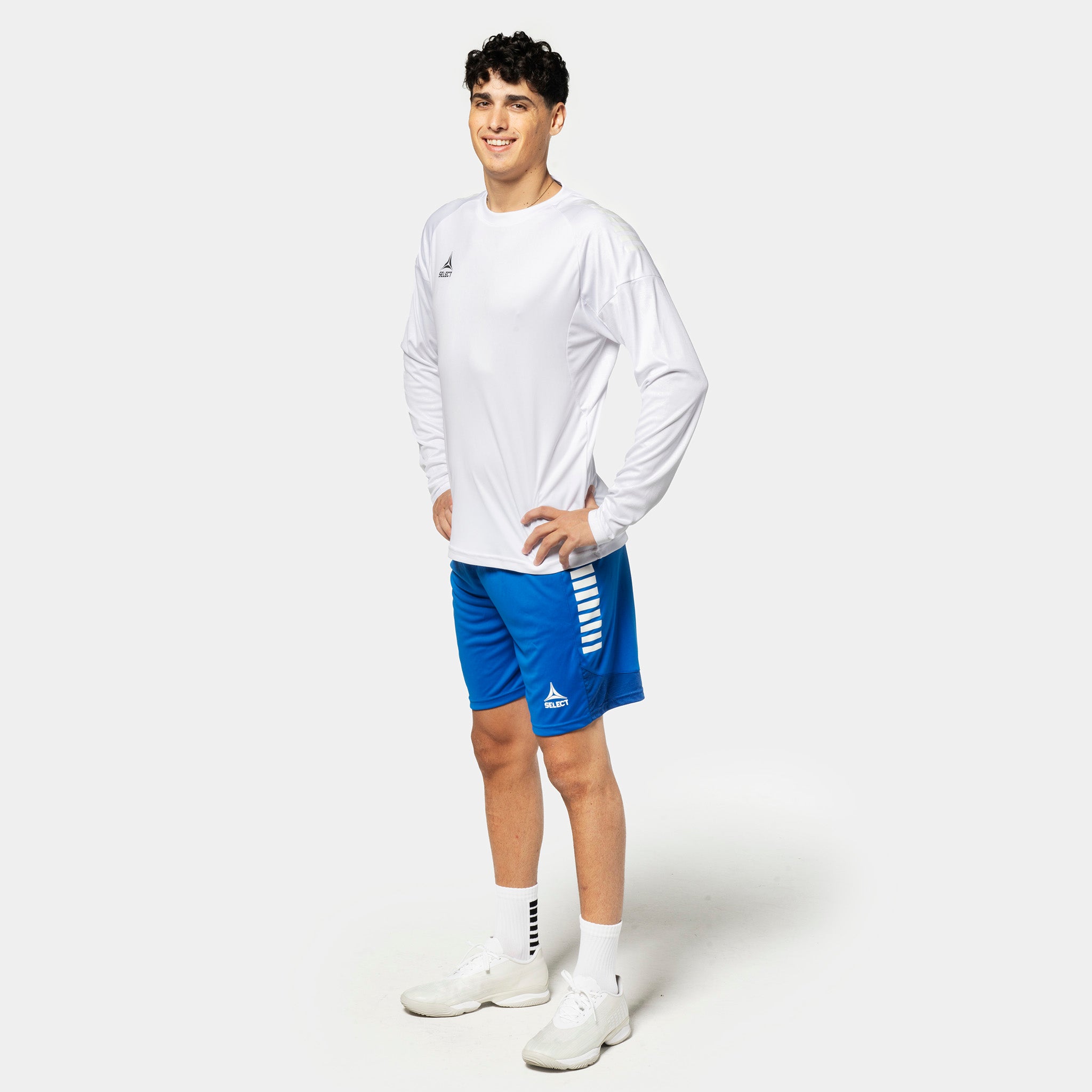Mannlig fotballspiller i hvit Player shirt L/S Spain v25 og blå shorts, Match & Training wear.