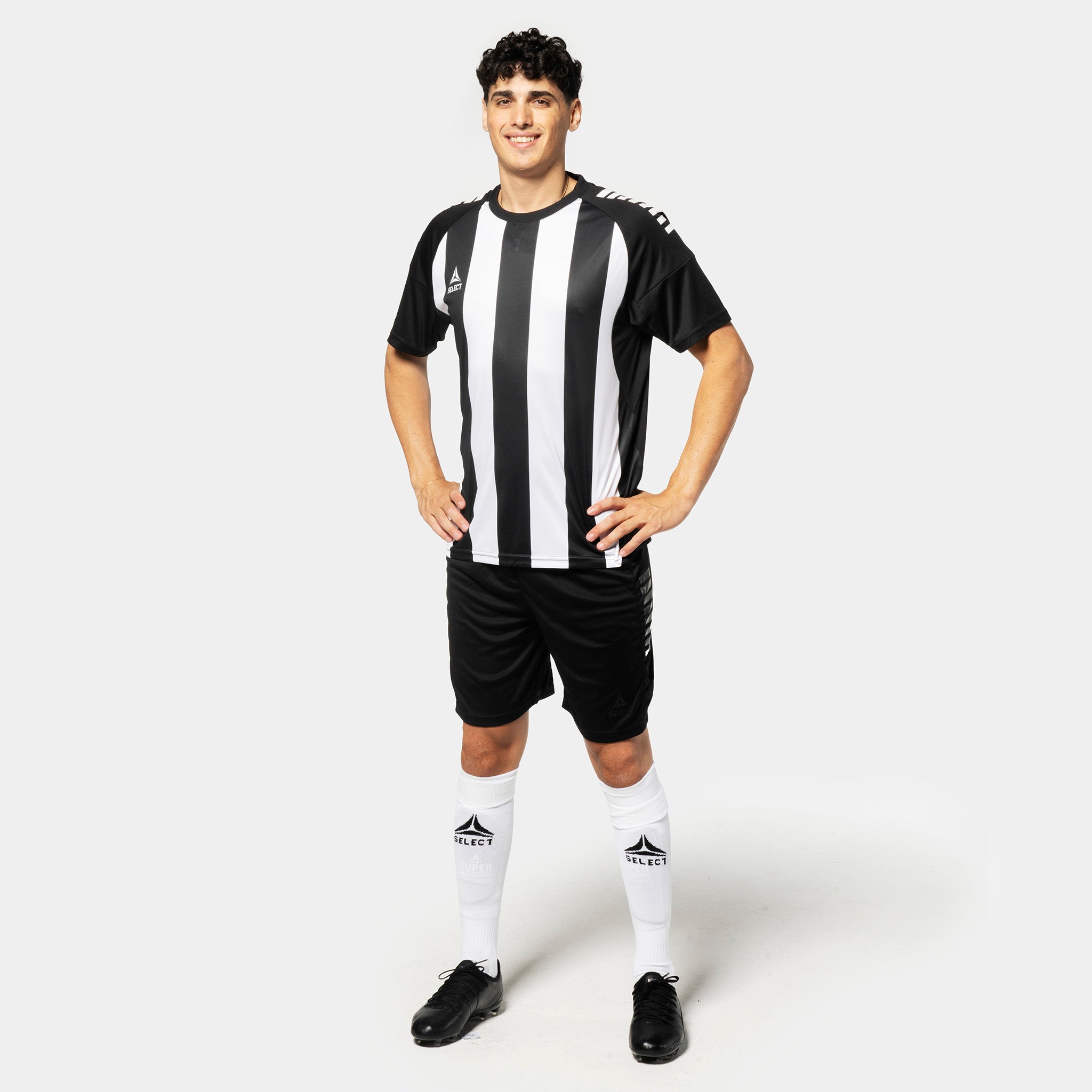 Mann i sort-hvit stripet Player shirt S/S Spain v25, sorte shorts, hvite strømper. Football Match & Training wear, sett forfra.