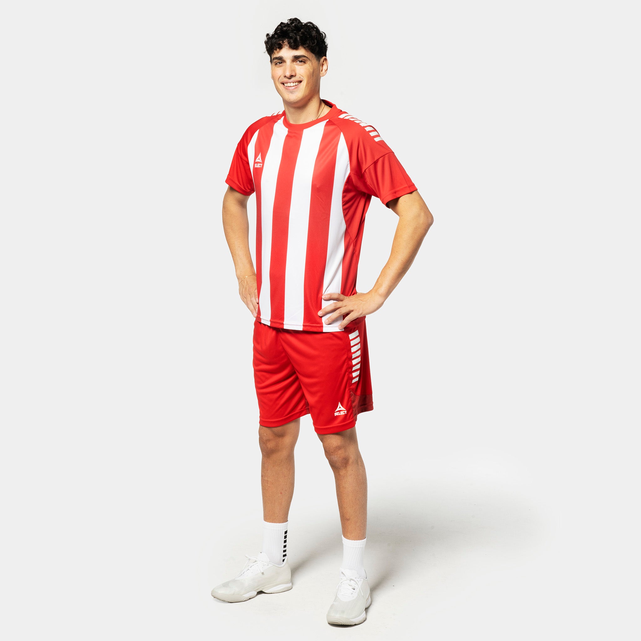 Mannlig fotballspiller i rød- og hvitstripet Player shirt S/S Spain striped v25 med røde shorts, Match & Training wear.