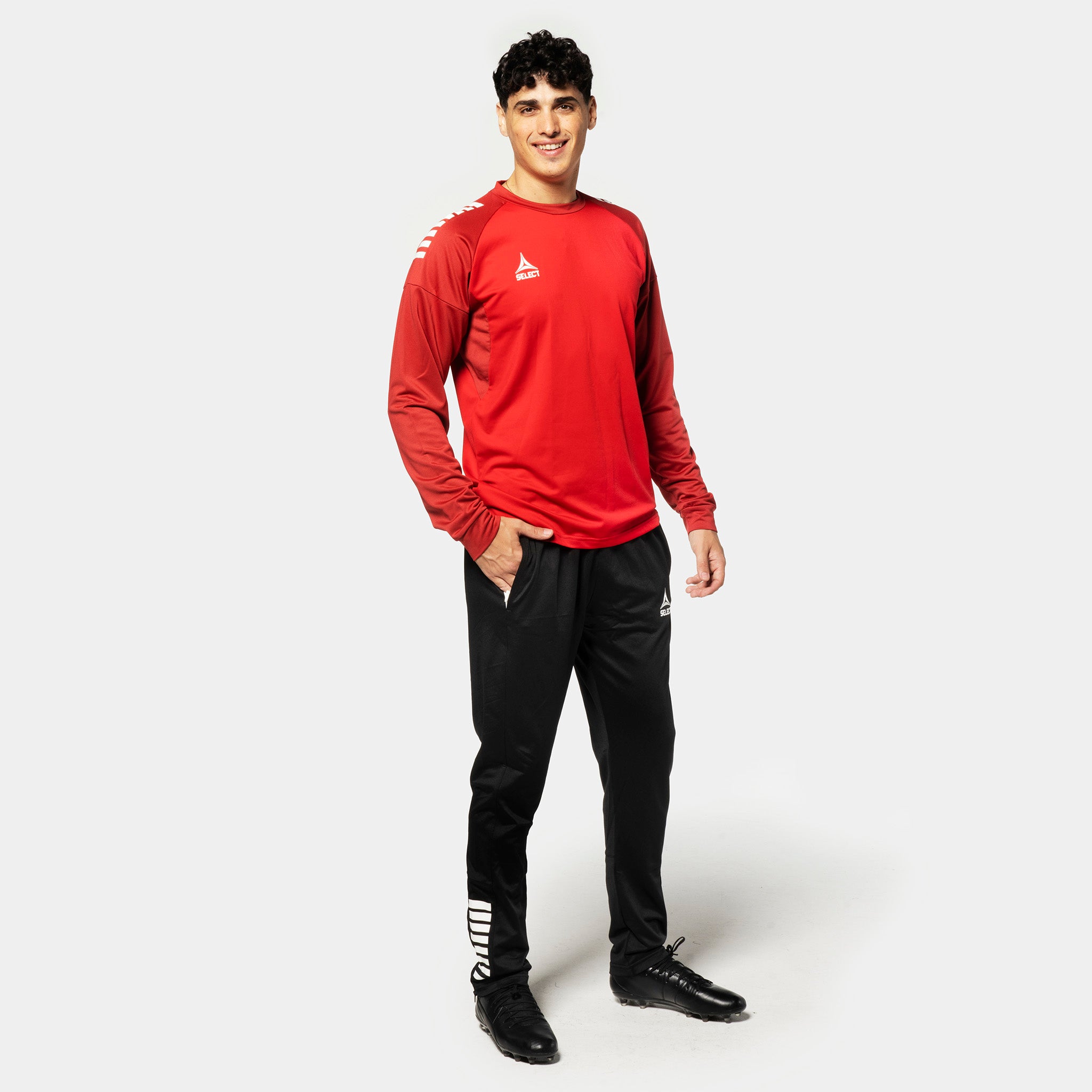 Mannlig fotballspiller i rød og hvit Training sweat Spain v25, Match & Training wear, med svarte bukser, sett forfra
