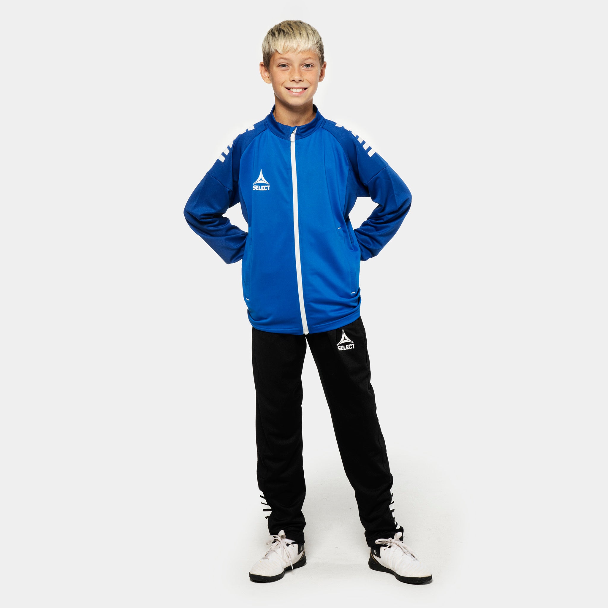 Gutt fotballspiller i blå Training zip jacket & sort Training pants regularFit Spain v25, Match & Training wear, forfra