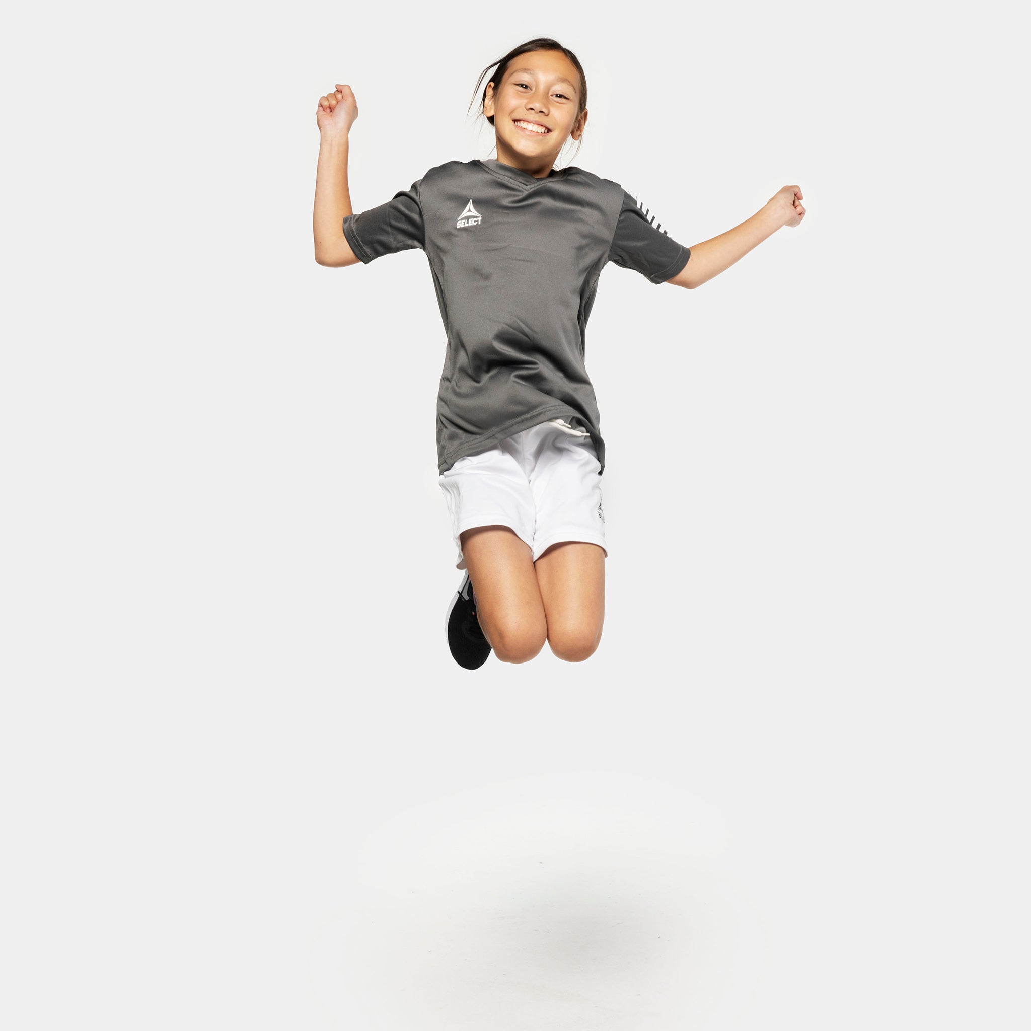 Gutt fotballspiller hopper i grå trøye og hvite Player shorts Pisa, Match & Training-klær.