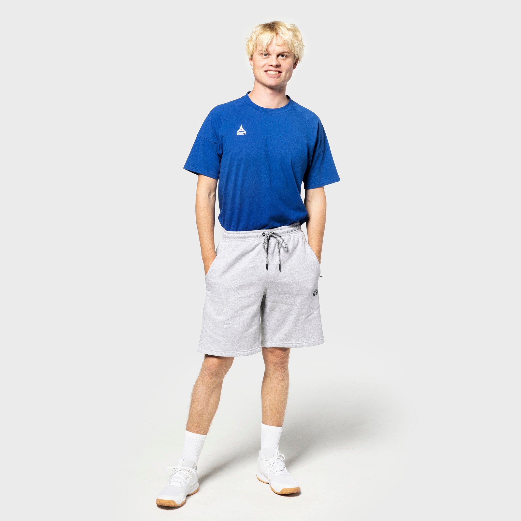 Mannlig fotballspiller i blå t-skjorte og grå Sweat shorts Oxford v25, fritidsklær, forfra.