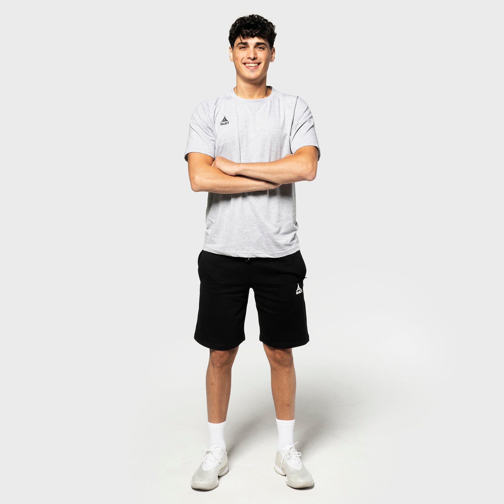 Mannlig fotballspiller i grå t-skjorte og svarte Sweat shorts Oxford v25, fritidsklær, forfra.