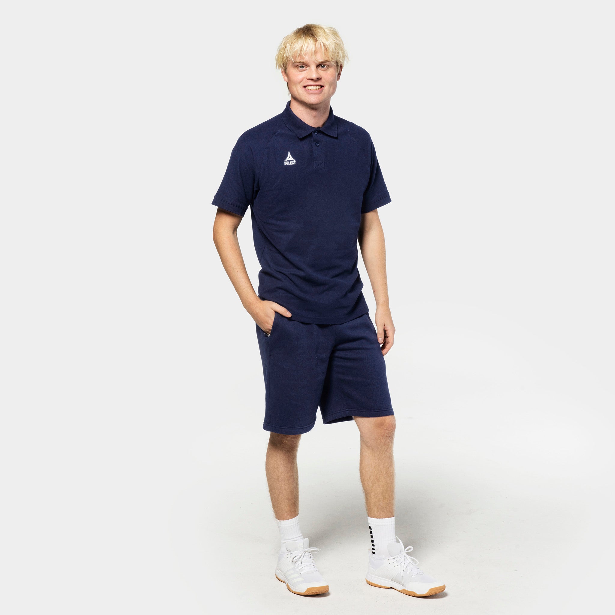 Mannlig fotballspiller i marineblå Sweat shorts Oxford v25 og matchende polo, Leisure wear, sett forfra.