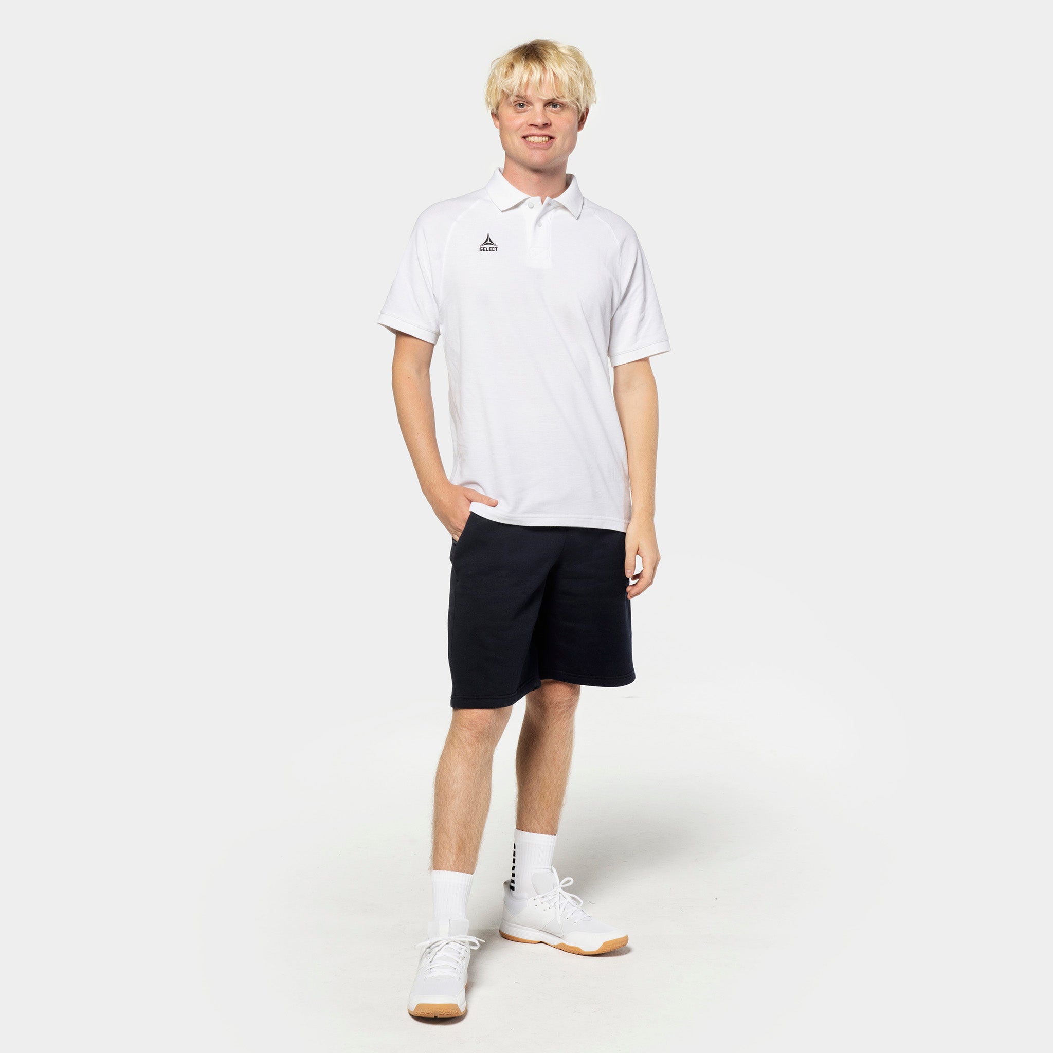 Mannlig fotballspiller i hvit poloskjorte og sorte Sweat shorts Oxford v25, fritidsklær, forfra.