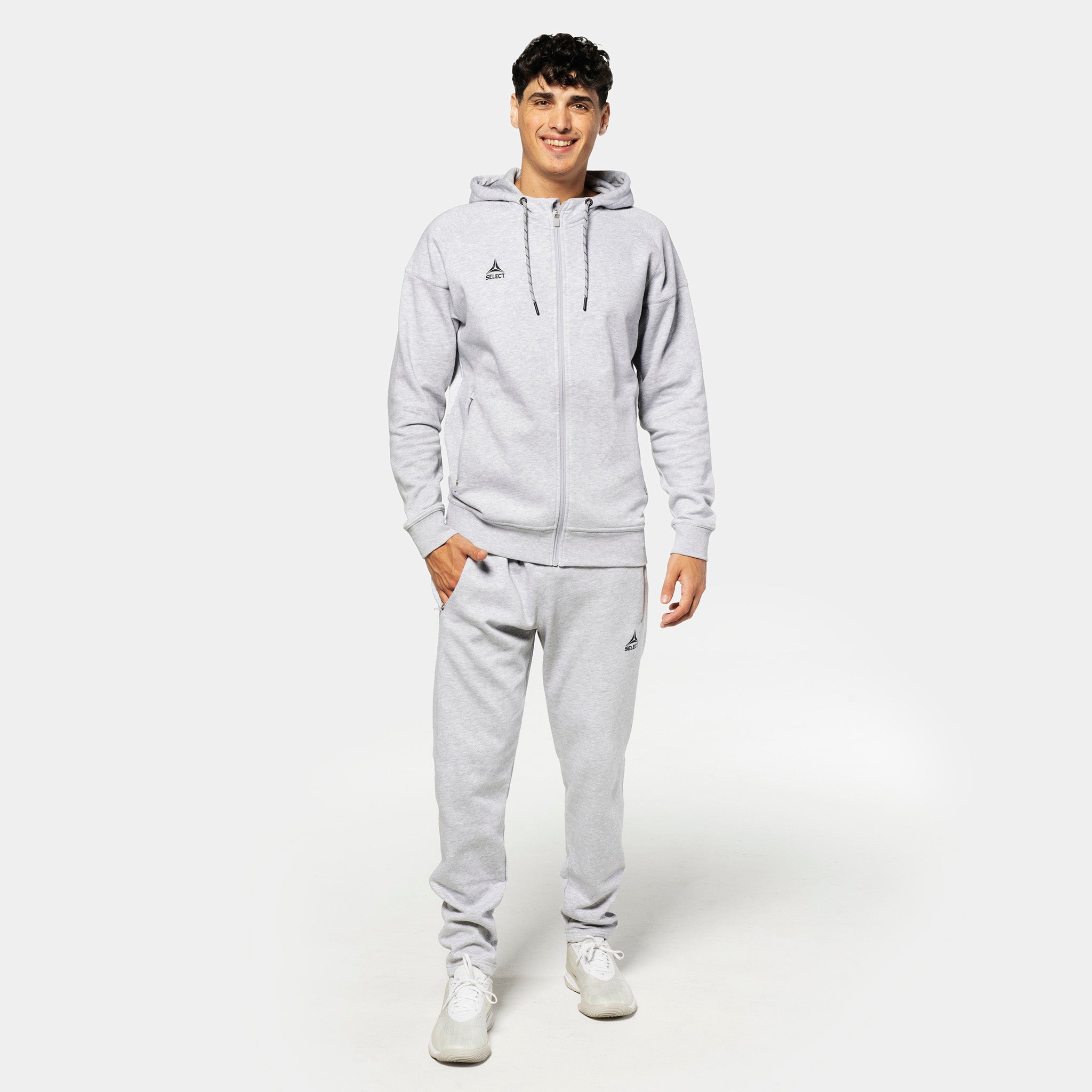 Mannlig fotballspiller i grå Sweat pants Oxford v25 med matchende hettegenser, fritidsklær, forfra.