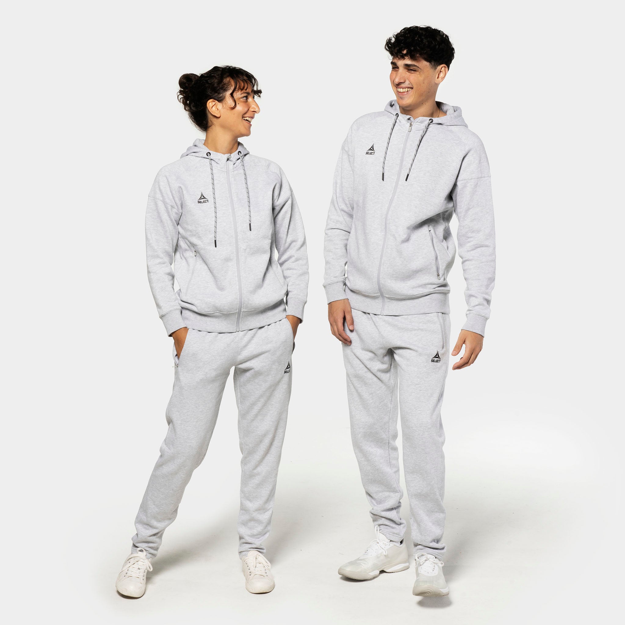 Kvinnelig og mannlig fotballmodell i grå Sweat pants Oxford women v25 fritidsklær med matchende zip-hettegensere, forfra.