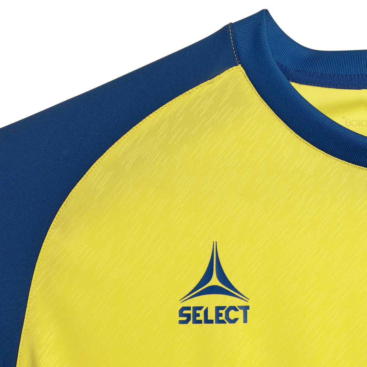 Nærbilde av gul & blå Player shirt S/S Pisa X, Match & Training wear, viser stoff & Select-logo foran.