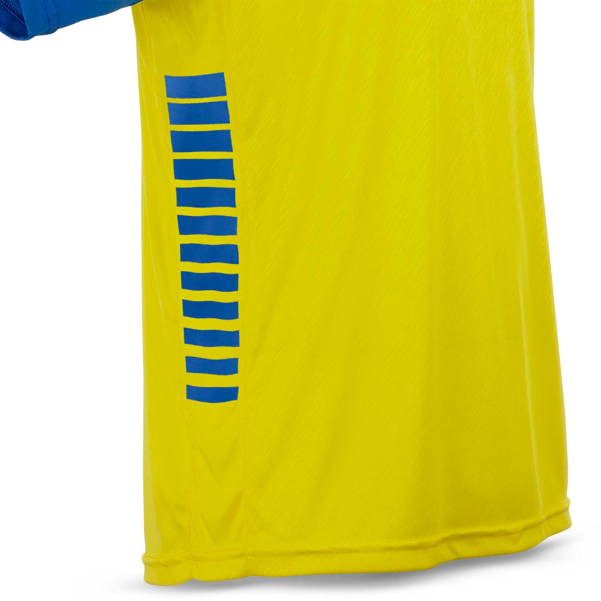 Nærbilde av gul Player shirt S/S Pisa X, Match & Training wear, med blåstripet detalj på siden.