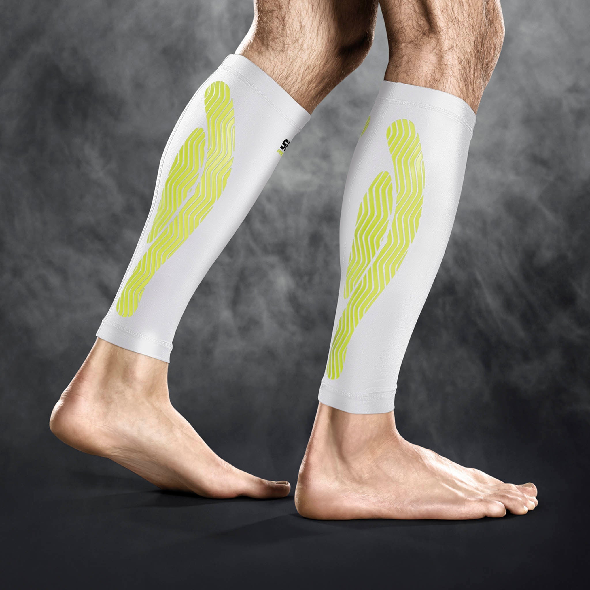 Hvit Compression Calf 6150 sportsstøtte med gult mønster, båret på begge legger, sett forfra.