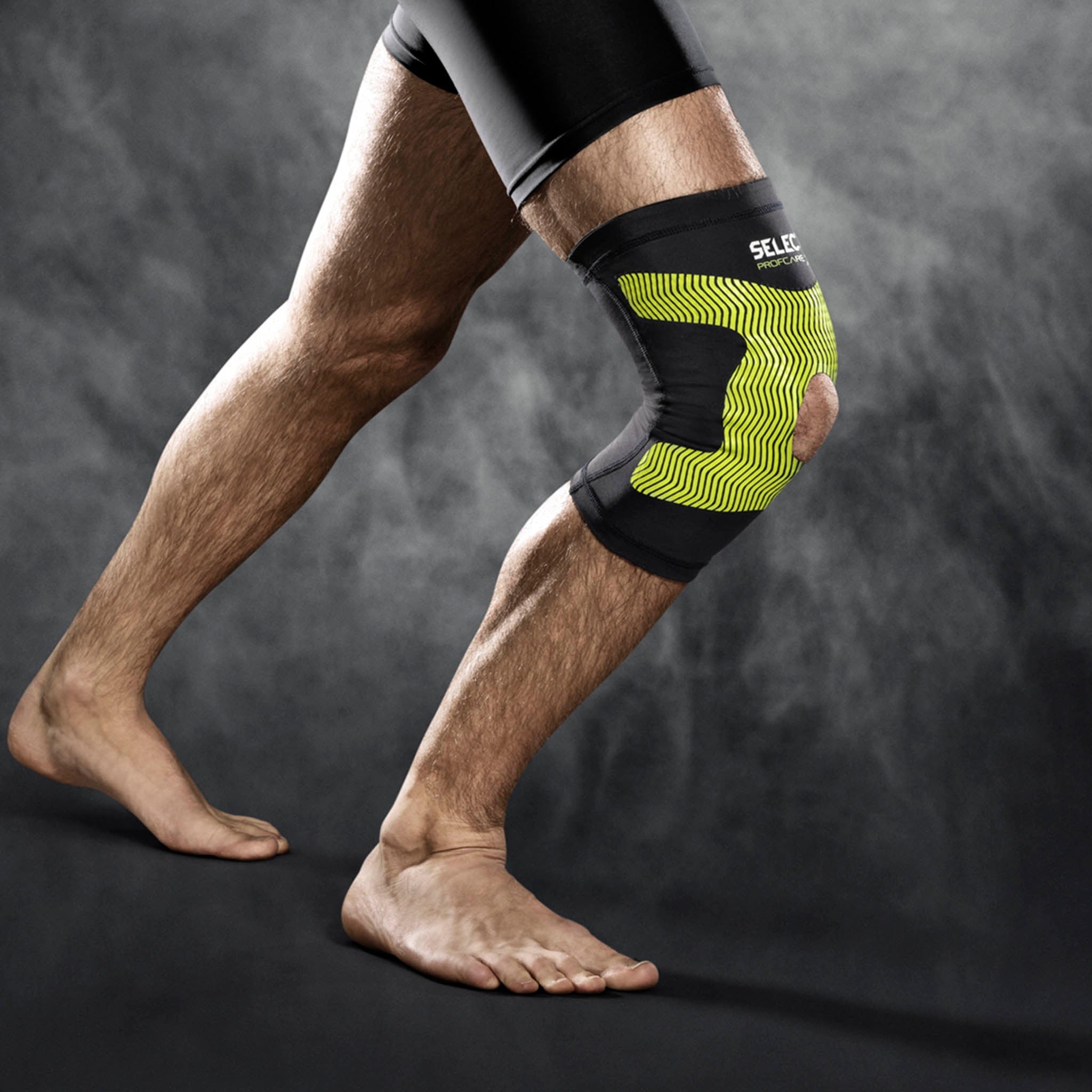 Mann med svart og gul Compression knee support 6252, sportsstøtte, på kneet