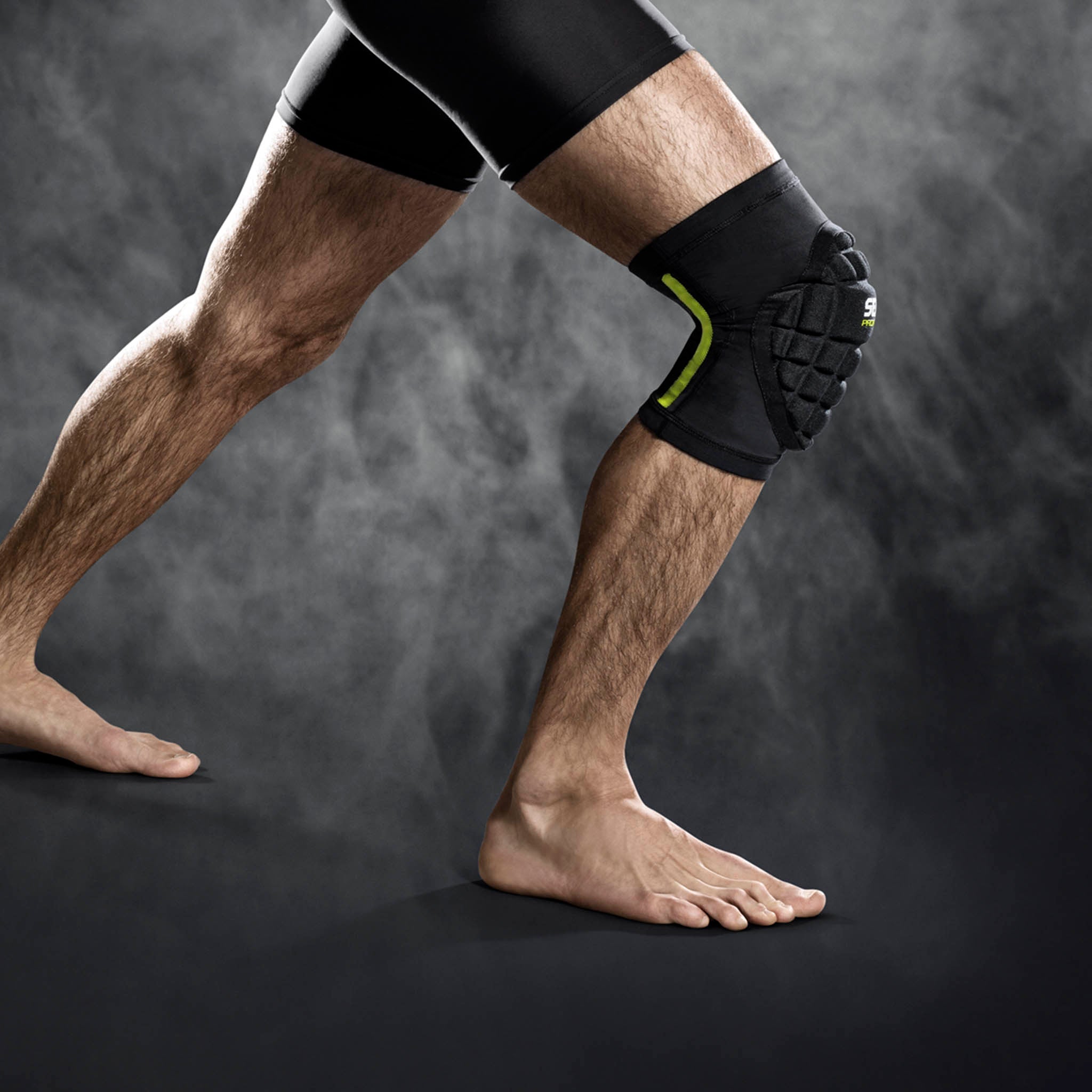 Svart Compression knee handball 6250 sportsstøtte med grønn detalj, båret på kne, forside