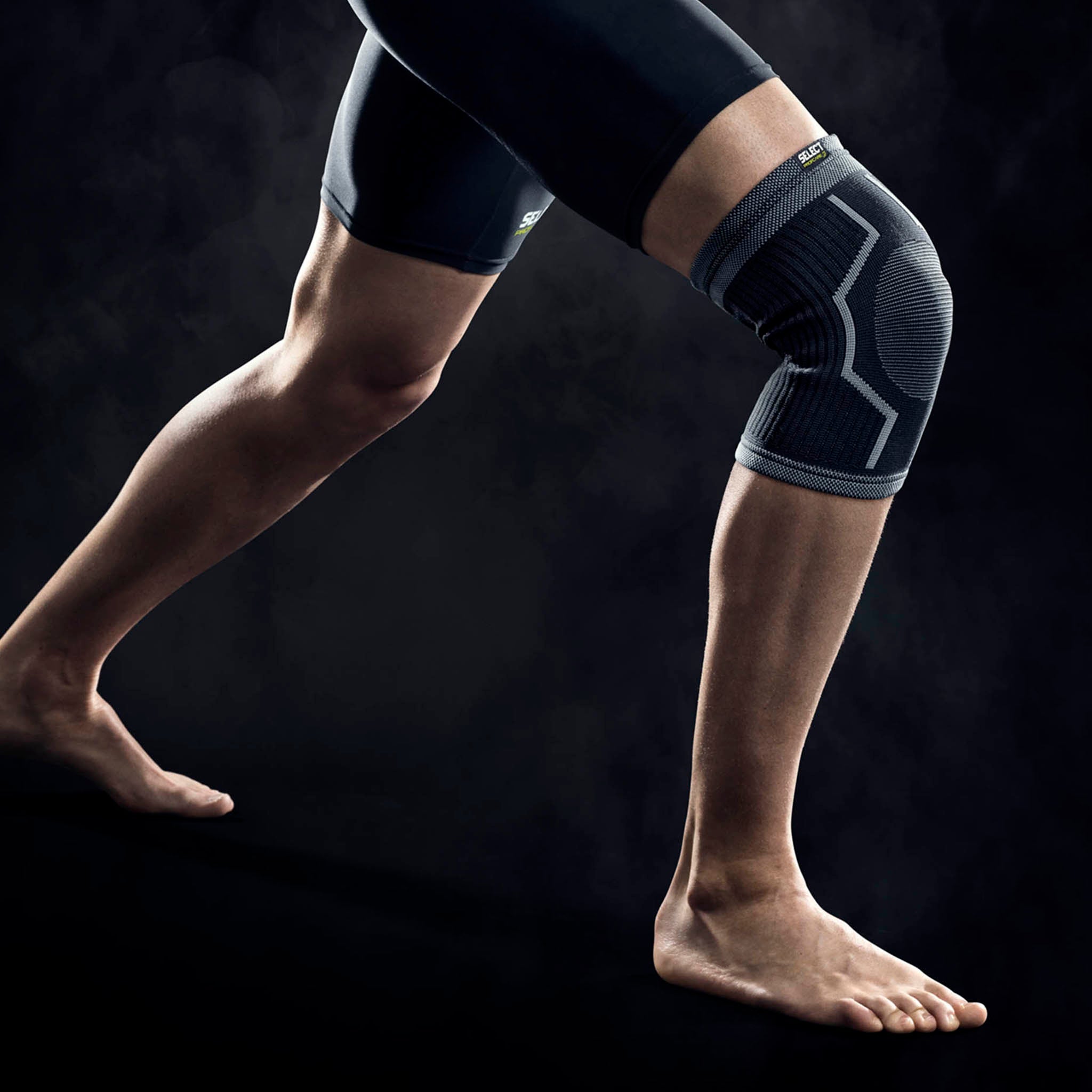 Fotballspiller med svart Knee support sportsstøtte, modellbilde