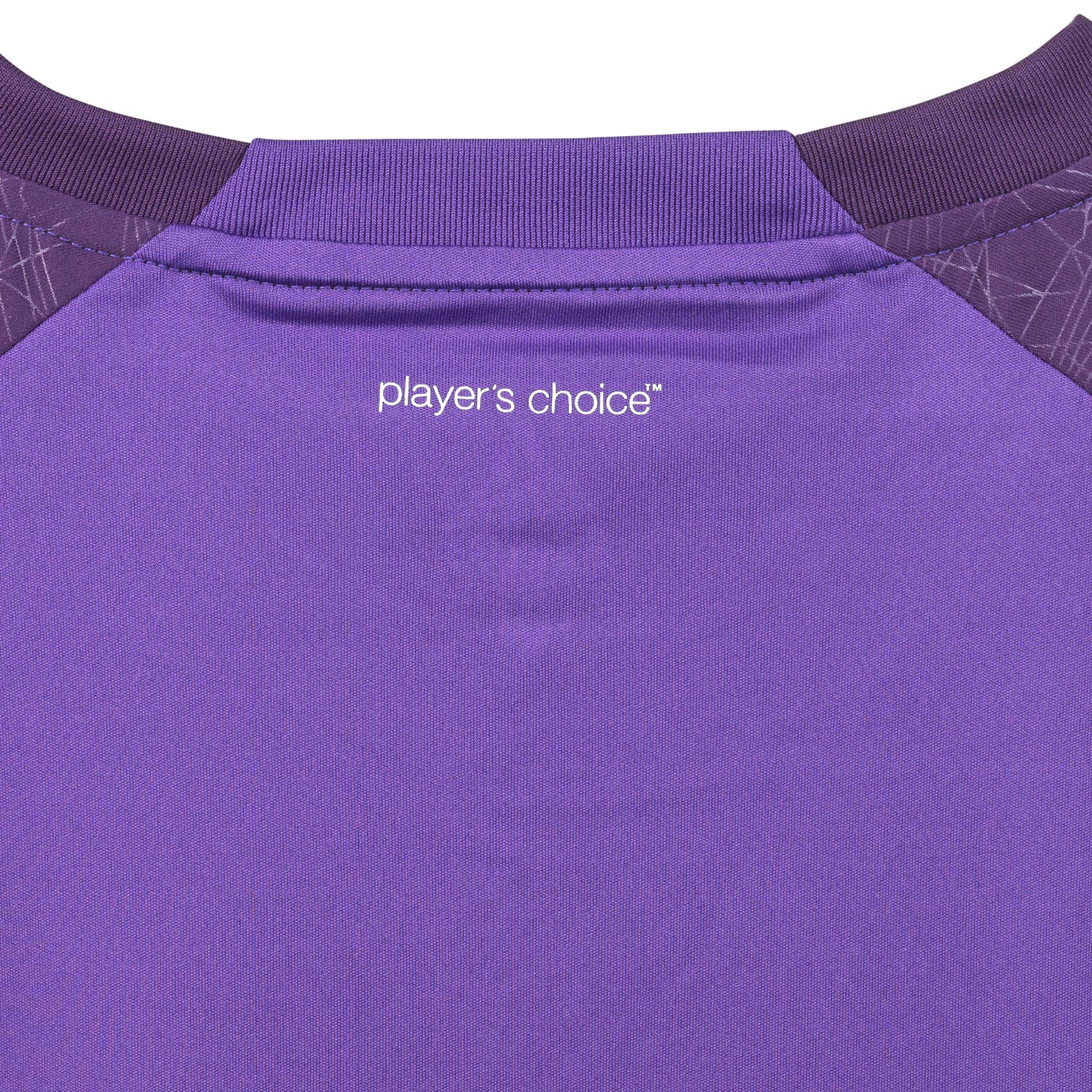 Nærbilde av lilla Player shirt S/S Spain woman v25, Match & Training wear, med hvit "player's choice"-tekst og ribbet krage.